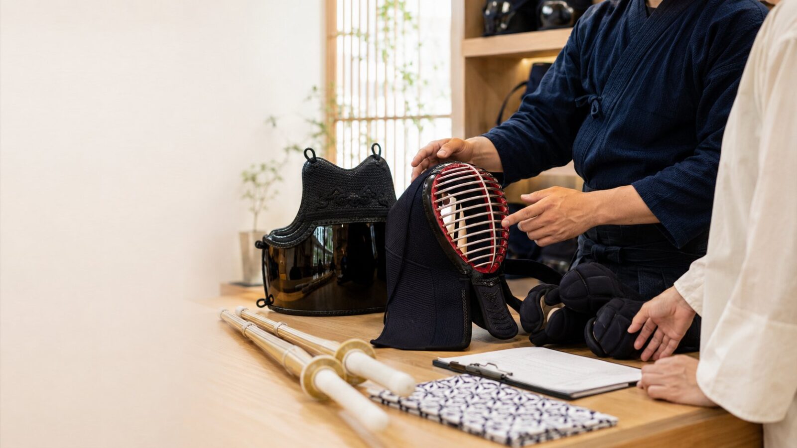 KOBUDO staff explaining a men and do during an armor consultation